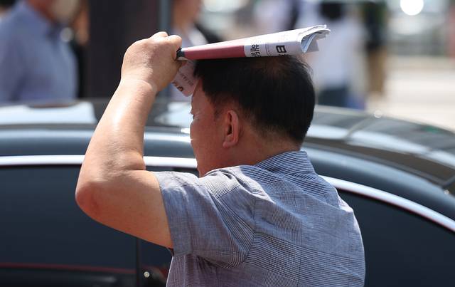 대구에 올해 첫 폭염주의보가 발령된 27일 동대구역 인근에서 한 시민이 신문으로 햇볕을 가리고 있다. 연합뉴스