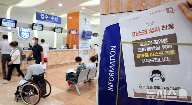 [인천=뉴시스] 전진환 기자 = 사진은 지난해 8월 22일 인천 서구 국제성모병원 로비에서 병원 직원이 원내 출입 시 마스크 착용을 권고하는 안내문을 붙이고 있는 모습. 2024.08.22. amin2@newsis.com