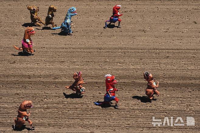 [오번=AP/뉴시스] 지난달 29일(현지 시간) 미국 워싱턴주 오번의 경마장 에메랄드 다운스에서 열린 '티렉스 세계 챔피언십 레이스'에서 참가자들이 결승선을 향해 달리고 있다. 2025.07.01.