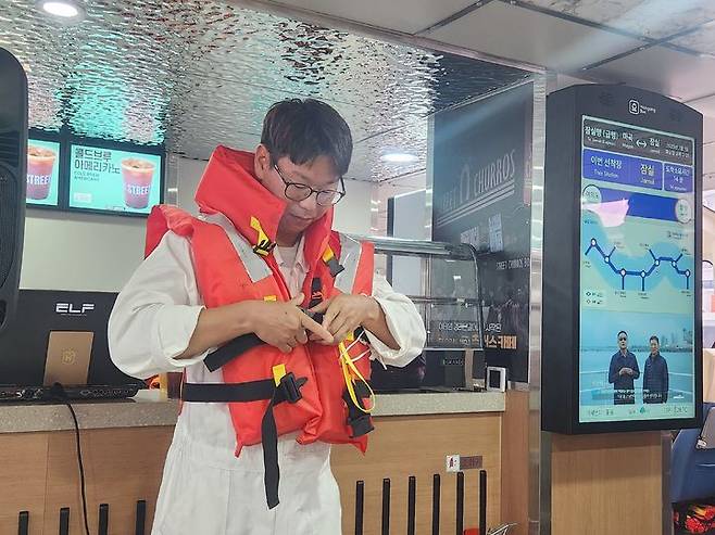 [서울=뉴시스] 고가혜 기자=한강버스 출발 전 구명조끼 착용법을 설명하는 승무원. 2025.07.01 gahye_k@newsis.com *재판매 및 DB 금지