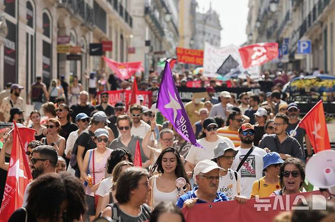 [AP/뉴시스] 포르투갈 수도 리스본에서 지난달 28일 고온의 뜨거운 날씨 속에 주택 위기에 항의하는 시위대가 행진하고 있다