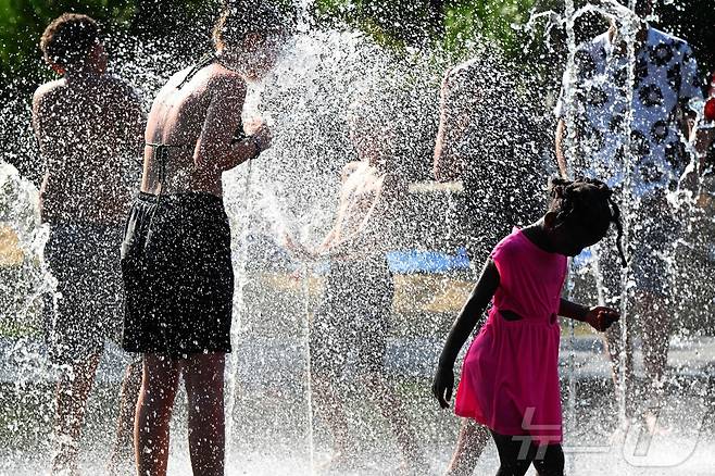 1일(현지시간) 프랑스 북부 랭스의 한 분수대에서 시민들이 물을 맞으며 더위를 식히고 있다. ⓒ AFP=뉴스1