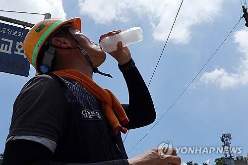 엿새째 폭염특보가 내려진 2일 광주 서구 금호동 한 공사장 앞에서 한 건설노동자가 더위를 달래기 위해 얼음물을 마시고 있다. [광주=연합뉴스]