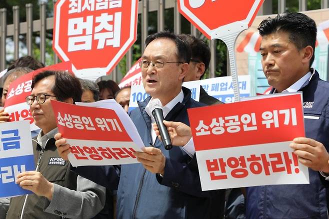 송치영 소상공인연합회 회장이 지난 6월 26일 세종시 정부세종청사 고용노동부 앞에서 진행된 기자회견에서 2026년도 최저임금 동결을 촉구하는 손팻말을 들고 소상공인의 생존권 보장을 요구하고 있다. 소상공인연합회 제공