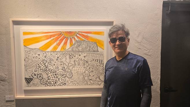 최 용 씨가 자신의 젠탱글 아트 작품 - 성산을 소개하고 있다.