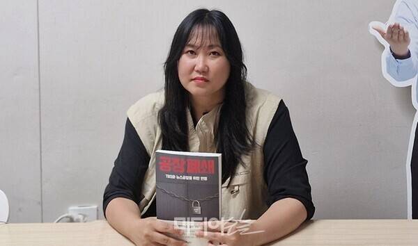 ▲송지연 TBS전국언론노동조합 지부장이 6월25일 출간된 책 '공장 폐쇄'를 들고 있다. 사진출처=송지연 제공.