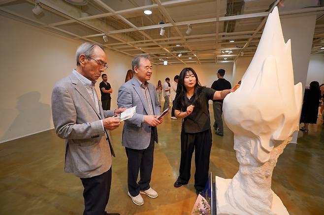 세계청소년문화재단의 설립자이자 이사장을 맡고있는 강영중 대교그룹 명예회장(왼쪽에서 두번째)이 ‘2024 대교국제조형심포지엄’ 작품 전시회 문체부장관상 수상자(대상)에게 작품 설명을 듣고 있다.  <세계청소년문화재단>