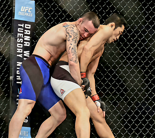 웰터급 6위 출신 김동현이 2017년 6월 싱가포르체육관 UFC 파이트 나이트 111에서 훗날 잠정 챔피언이 되는 콜비 코빙턴한테 등을 내주고 있다. 체념한 김동현과 여유 있는 코빙턴의 표정이 대조적이다. 사진=Getty Images=연합뉴스 제공