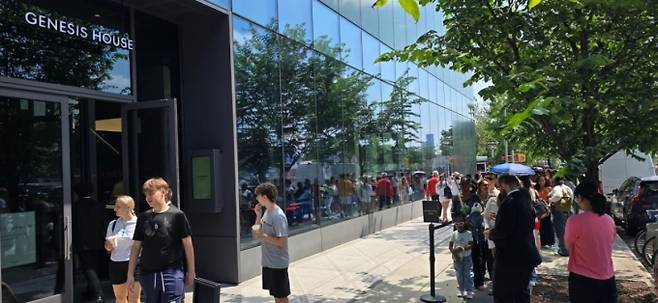 지난 28일(현지시간) 뉴욕 맨해튼의 제네시스하우스 앞 도로에 '한국의 숲: 더 포레스트 위딘' 전시를 관람하려는 관람객들이 건물을 돌아 줄을 서 있는 모습이 전시장 유리창에 비쳐 보인다. /사진=심재현 특파원