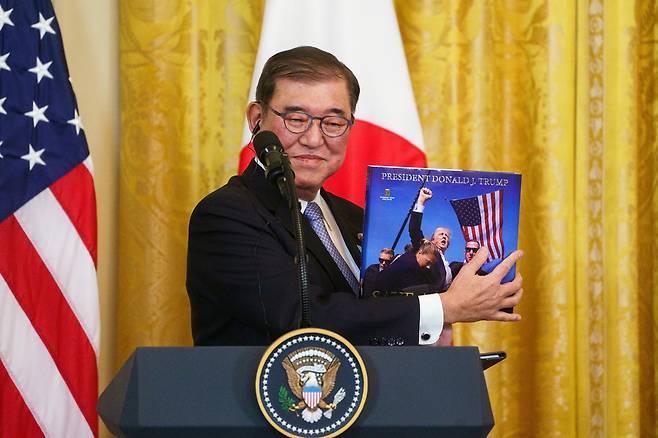 지난 2월 7일 미국 워싱턴 DC 백악관에서 열린 도널드 트럼프 대통령과의 기자회견에서 이시바 시게루 일본 총리가 미국 측으로부터 받은 선물을 공개하고 있다. [EPA]