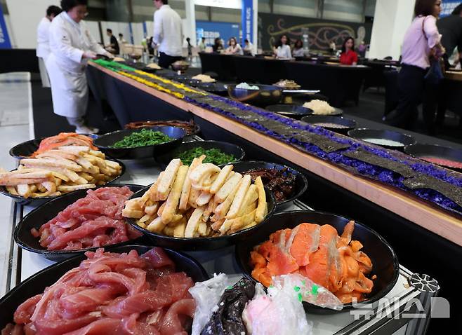 [서울=뉴시스] 이영환 기자 = 2일 식품의약품안전처가 발간한 '건강 식생활 실천 정보집'에 따르면 육류·면과떡·단 음료·양념류 위주의 식단보다 해산물·해조류 위주 식단이 만성질환 유별률이 낮았다. 지난 1일 오전 서울 강남구 코엑스에서 열린 2025 코리아씨푸드쇼에서 한식대가들이 해산물 김밥을 만들고 있다. 해당 사진은 기사와 직접 관련이 없습니다. 2025.07.01. 20hwan@newsis.com