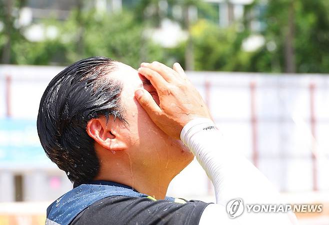 '뜨겁다, 뜨거워' (대구=연합뉴스) 박세진 기자 = 2일 대구 중구 한 건설현장에서 작업자가 냉수로 세수하며 무더위를 식히고 있다. 2025.7.2 psjpsj@yna.co.kr