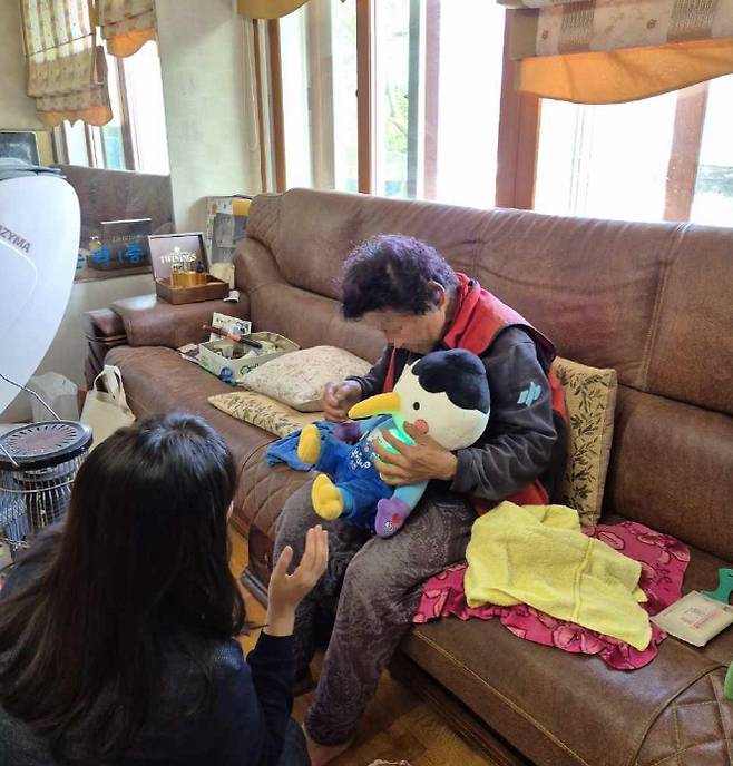 순천시 관계자가 어르신에게 AI 반려로봇 '루미'에 대해 설명하고 있다.