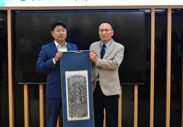 박민원(왼쪽) 국립창원대학교 총장이 한인 이민 1세대 이만정 선생의 후손인 이은환 씨에게 이만정 선생의 묘비 탁본을 전달하고 있다. /국립창원대학교