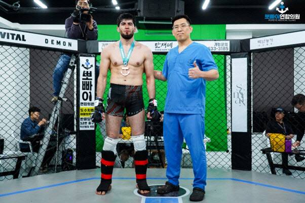 KMMA 30회 대회서 승리한 ‘블랙샤크’ 샤크 그로즈니에게 메인스폰서인 뽀빠이연합의원 김성배 대표원장이 시상하고 있다. 사진=KMMA