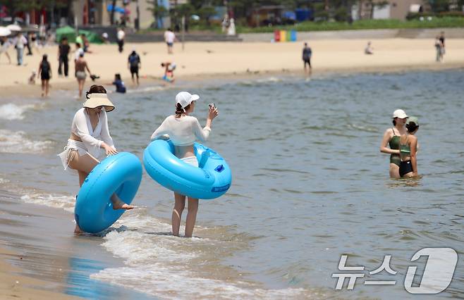 무더위가 기승을 부린 1일 개장한 부산 수영구 광안리해수욕장을 찾은 관광객들이 물놀이를 즐기며 더위를 식히고 있다. 부산 7개 해수욕장 중 해운대·송정해수욕장은 지난달 21일 개장했으며, 광안리·송도·다대포·일광·임랑해수욕장 등 5개 해수욕장은 이날 문을 열었다. ⓒ News1 윤일지 기자