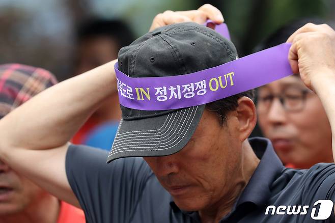 2023년 7월 10일 오전 경기도 양평군청 앞에서 열린 '서울-양평 고속도로 재개 범군민 대책위원회 출정식'에 한 지역주민이 사업 재개를 촉구하는 머리띠를 두르고 있다.  2023.7.10/뉴스1 ⓒ News1 이승배 기자