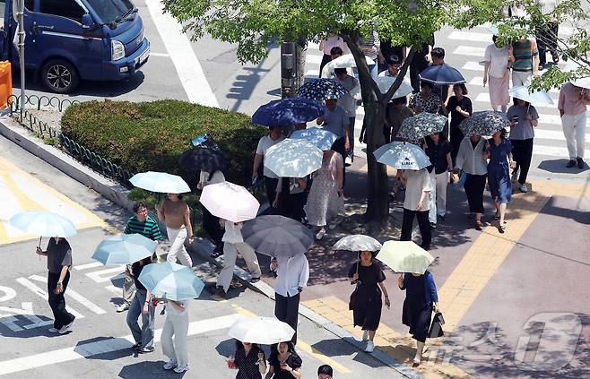 찜통더위가 이어지고 있는 3일 광주 북구청 교차로에 구청 공직자들이 점심시간 양산을 쓰고 이동하고 있다. (광주 북구 제공. 재판매 및 DB 금지) 2025.7.3/뉴스1 ⓒ News1 박지현 기자