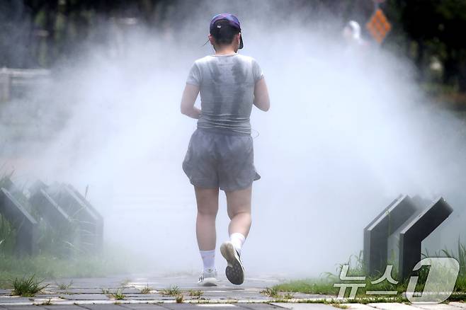일주일째 폭염특보가 이어진 3일 대구 중구 김광석길 입구 산책로에서 달리기하던 한 시민이 쿨링포그 사이를 걸으며 숨을 고르고 있다. 2025.7.3/뉴스1 ⓒ News1 공정식 기자