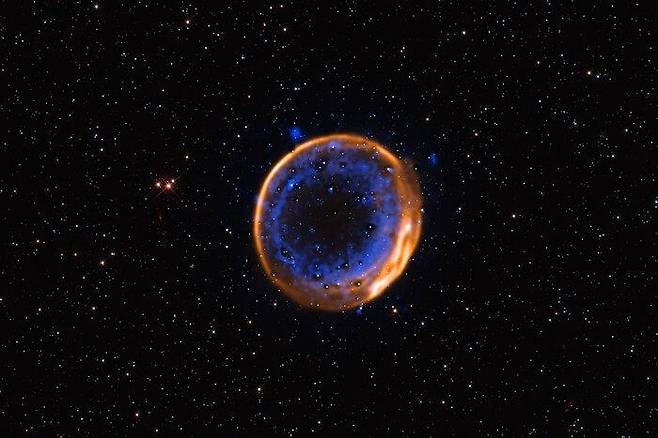 백색왜성의 이중폭발로 만들어진 초신성 잔해 'SNR 0509-67.5' 유럽남방천문대(ESO) 초거대망원경(VLT)으로 촬영한 초신성 잔해 'SNR 0509-67.5'. 16만 광년 떨어져 있는 이 초신성은 약 400년 전 지구에서 관측 가능한 밝기로 폭발했을 것으로 추정된다. VLT 광시야 분광 관측기(MUSE) 관측 결과 SNR 0509-67.5 주위에는 백색왜성이 폭발할 때 방출된 칼슘이 중심별에서 동심원 형태로 층을 이루고 있는 것으로 나타났다. [ESO/P. Das et al. Background stars (Hubble): K. Noll et al. 제공. 재판매 및 DB 금지]