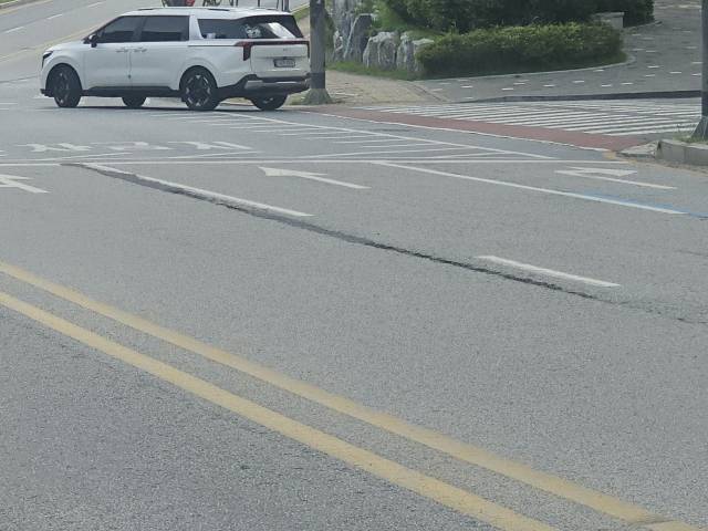 포장 공사 후 죠인트(이음매)가 차선 도색 위치가 아닌 차량 주행선에 시공돼 차량 무게를 견디지 못하고 균열이 발생한 모습, 시공 편의 위주 공사로 도로 하자가 반복되는 현장을 보여주고 있다.사진=김의상 기자