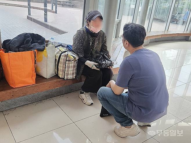 4일 오후 광주 서구 광주종합버스터미널(유스퀘어) 벤치에 앉아있는 노숙인에게 광주다시서기종합지원센터 상담요원이 도시락을 전달하며 안부를 묻고 있다. 강주비 기자