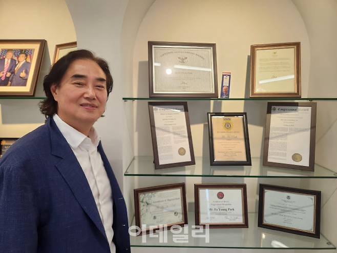 박화영 인코코그룹 회장이 지난달 30일 서울시 서초구 인코코캐피탈 사무실 복도에 진열된 상장들 앞에서 자세를 취하고 있다.(사진=이준기.)