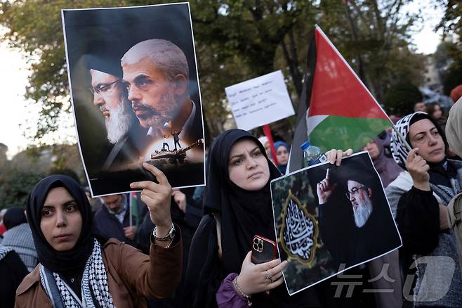 2024년 10월 20일 튀르키예 이스탄불에서 팔레스타인 지지 시위대가 전 하마스 지도자 야흐야 신와르 암살을 규탄하는 시위에 참여해 사이예드 하산 나사랄라 헤즈볼라 사무총장과 야흐야 신와르의 사진을 들고 있는 모습. 2024.10.20. ⓒ 로이터=뉴스1 ⓒ News1 윤다정 기자