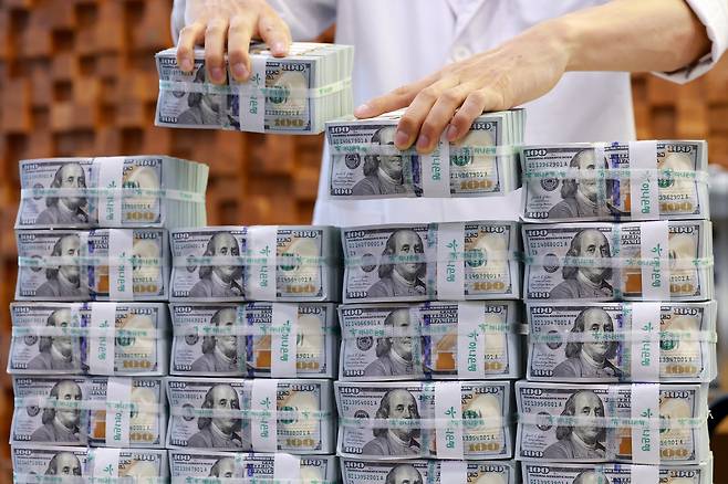 3일 서울 중구 하나은행 본점 위변조대응센터에서 직원이 미국 달러화를 들어 보이는 모습. /연합뉴스