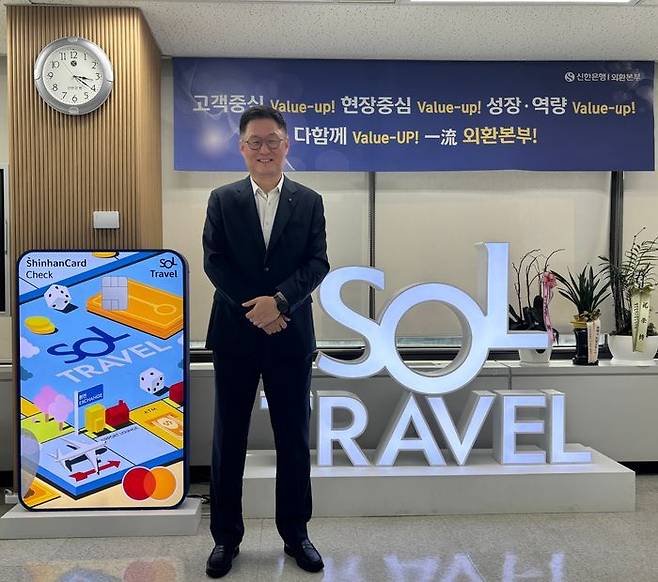 이해창 신한은행 외환본부장이 '쏠(SOL)트래블 체크카드' 입간판 앞에서 환하게 웃고 있다.ⓒ데일리안
