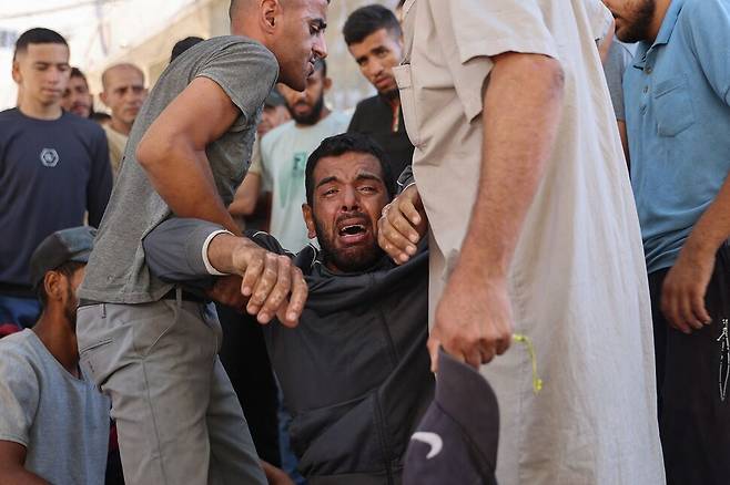 3일(현지시각) 가자 북부 가자시티 알시파 병원 밖에서 구호품 배급 과정에서 숨진 이들의 장례가 치뤄지는 중 한 남성이 눈물을 흘리고 있다. 가자시티/AFP 연합뉴스