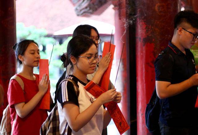 지난달 23일 베트남 하노이 문묘에서 전국 고등학교 졸업시험을 앞둔 수험생 황잉(왼쪽 두 번째)이 제를 올리고 있다. 손에는 기도용 향과 자신의 바람을 담은 소원문을 들고 있다. 하노이=허경주 특파원