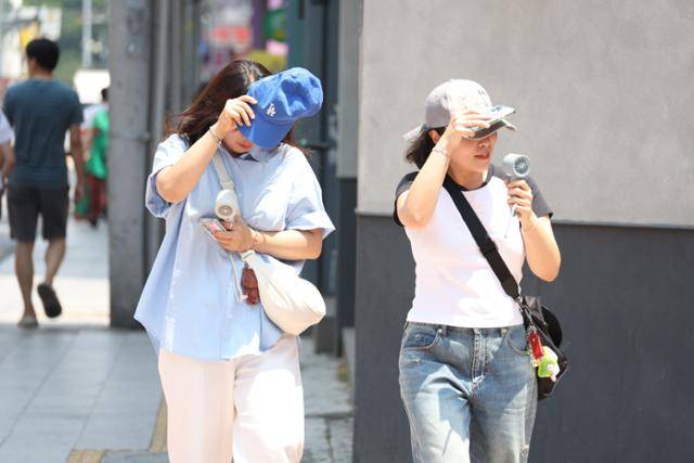 폭염경보가 내려진 지난달 28일 대구 중구 동성로에서 시민들이 햇빛을 가리며 발걸음을 옮기고 있다. 연합뉴스