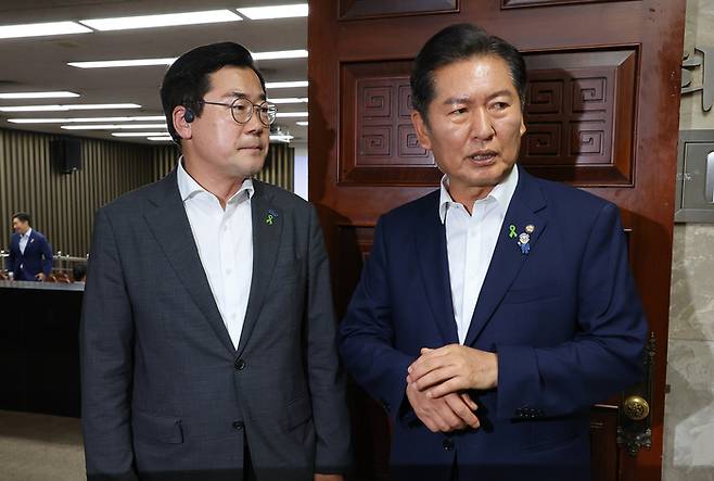 더불어민주당 당대표 후보자인 정청래(오른쪽)·박찬대 의원이 3일 서울 여의도 국회에서 열린 비공개 의원총회장 앞에서 대화하고 있다. [사진 출처 = 연합뉴스]