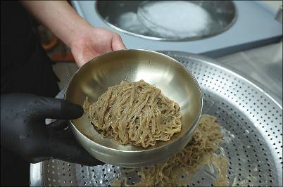 (3) 얼음물에 헹궈 쫄깃해진 메밀면을 놋그릇에 담는다.