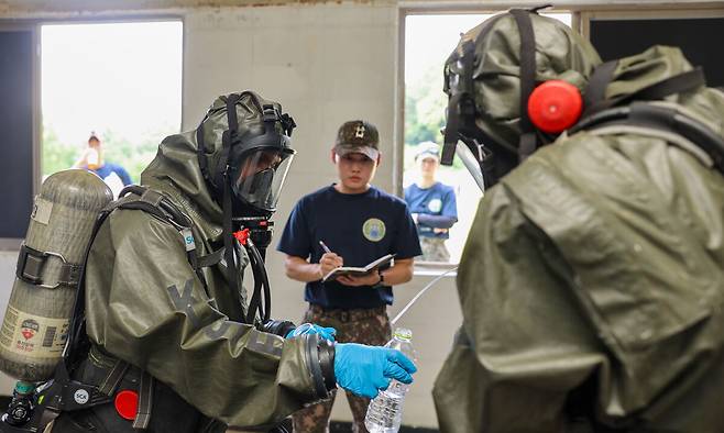 화학무기금지기구(OPCW) 국제화학방호교육 교육생들이 방호복을 입은 채 야외 실습을 하고 있다. 국방부 제공