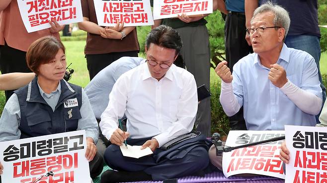 김민석 국무총리가 취임 후 첫 일정으로 4일 서울 용산구 대통령실 앞에서 송미령 농림축산식품부 장관 유임 결정 철회를 촉구하며 항의 농성 중인 농민단체와 면담 중 메모를 하고 있다.