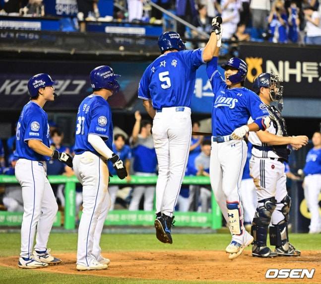 이재현이 만루 홈런을 쏘아올리고 세리머니를 하고 있다. 구자욱(가운데)이 하이파이브를 하고 있다.