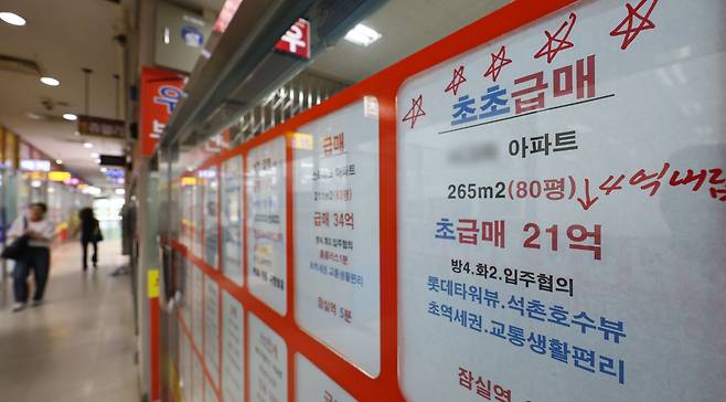 4일 서울 송파구에 있는 한 부동산 중개업소에 붙어 있는 아파트 급매 안내문. 기존 가격보다 4억원 이상 가격이 내려갔다는 안내가 적혀있다./연합뉴스