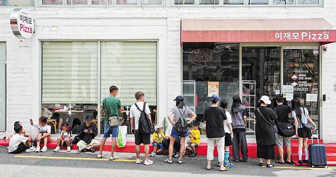폭염 특보가 발효된 지난 1일 부산 전포동 이재모 피자 서면점 앞. 평일 오후 1시인데도 사람들이 줄을 서 있다. 이 가게가 웨이팅 기계를 도입한 이후 최대 4~5시간씩 서 있어야 하던 대기 줄이 크게 줄었지만, 매장 앞은 여전히 손님들로 북적거렸다. /김용재 영상미디어 기자