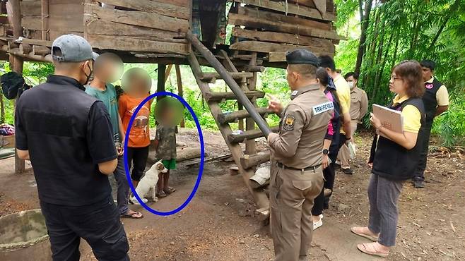 개들과 방치됐다 태국 경찰에 구조된 8살 소년(파란색 원). 사진=태국 카오솟 캡처