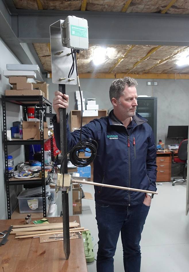 마이크 로스 인디시움 다이나믹스 CTO가 토양 수분감지 기기에 대해 설명하고 있다. 기기 아래쪽에 오른쪽으로 길게 튀어나온 것이 수분을 흡수하는 나무 막대다.