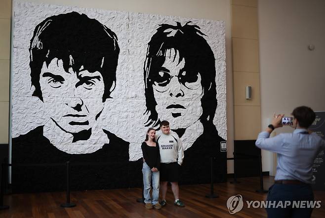 갤러거 형제 벽화 앞에서 기념촬영하는 팬들 [EPA 연합뉴스 재판매 및 DB 금지]