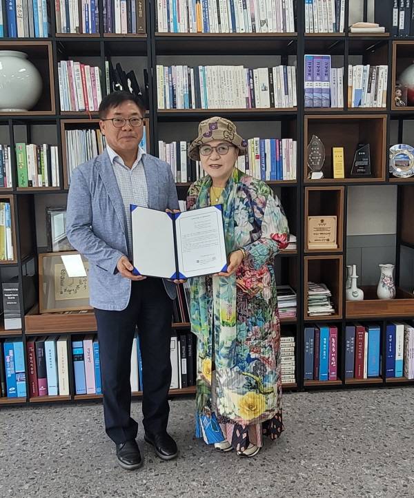 정창훈(왼쪽) 경남매일 대표가 정영숙 제1회 국제디카시공모전 대회장에게 위촉장을 전달하고 기념촬영을 하고 있다.