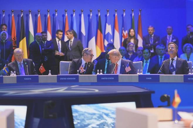 도널드 트럼프 미국 대통령이 지난달 25일(현지 시간) 헤이그 나토 정상회의 총회 개회무렵 옆의 키어 스타머 영국총리와 말하고 있다. 튀르키예의 에르도안 대통령과 뤼터 나토 사무총장이 옆에 보인며 뒤쪽에 미국의 루비오 국무장관, 헤그세스 국방장관 및 수지 와일스 비서실장이 보인다. AP·뉴시스