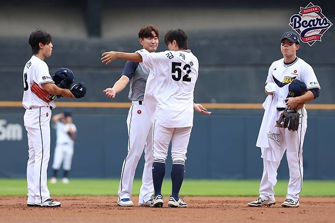 6일 잠실 KT 위즈전에서 박준순에게 '52번 유니폼'을 건네주는 김재호. 두산 제공