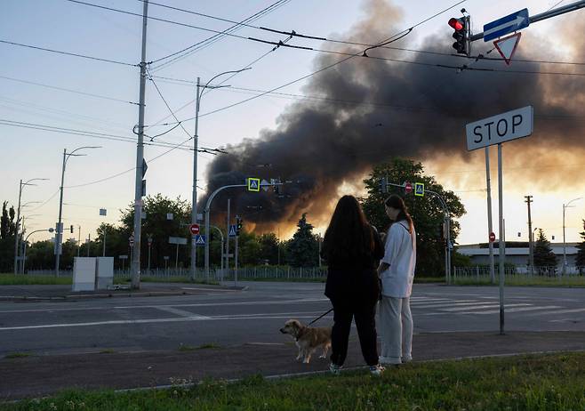 4일(현지시간) 러시아의 대규모 드론과 미사일 공습으로 우크라이나 수도 키이우에서 연기가 솟아오르고 있는 모습을 시민들이 지켜보고 있다. AFP연합뉴스