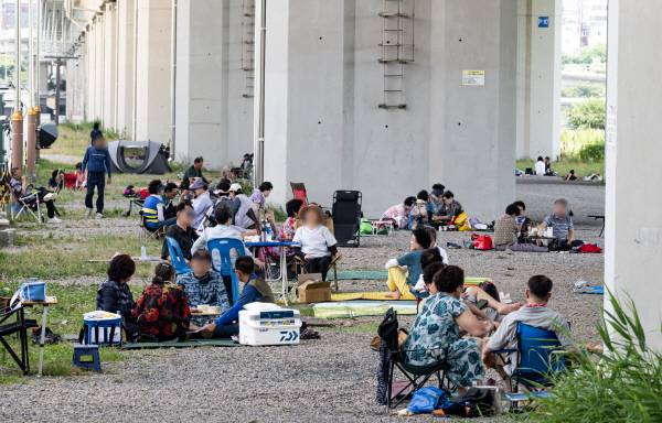 폭염과 열대야가 이어진 6일 부산 강서구 대저생태공원을 찾은 시민이 구포대교 아래그늘에서 휴식을 취하고 있다. 전민철기자 jmc@kookje.co.kr