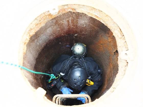 Officials search inside a manhole on July 6 in Incheon in search of a worker who went missing earlier in the day. [YONHAP]