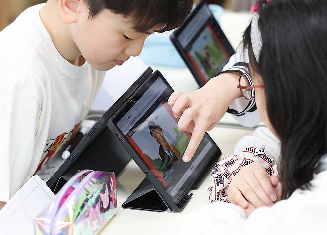 인공지능 디지털교과서(AIDT)가 당분간 교과서 지위를 유지할 것으로 전망되면서 개발사들이 한숨을 돌리고 있다. 사진은 대구 달성군 가창면 용계초등학교에서 열린 AI 디지털교과서(AIDT)를 활용한 공개수업. [연합]